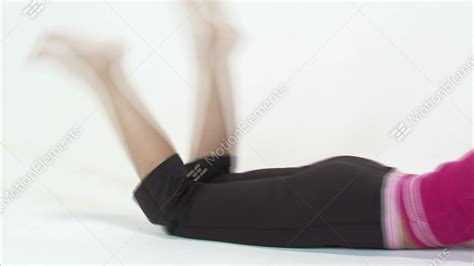 Pan Of A Woman Laying On Her Stomach Kicking Her Feet On A White