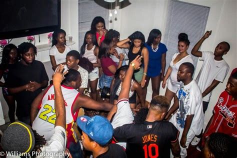 a group of people standing around each other in front of a tv and some fans