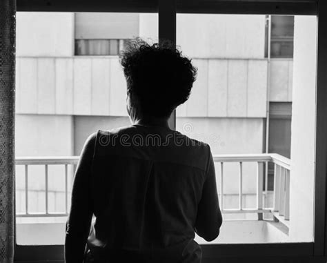 Grayscale Shot Of The Back Of A Woman Inside The House While Looking