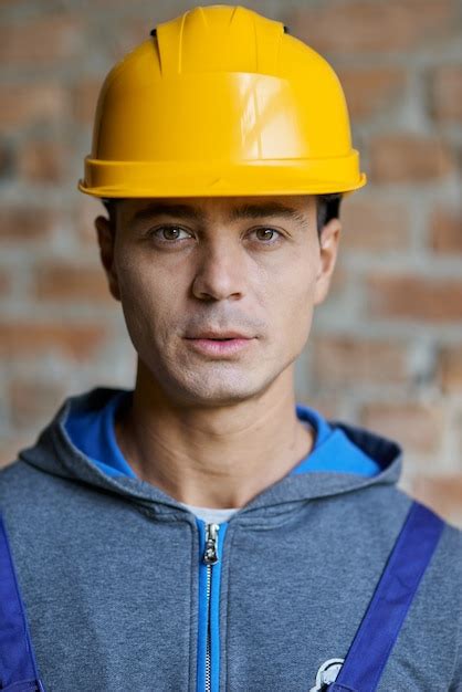Premium Photo Handsome Young Male Builder In Hard Hat Looking At