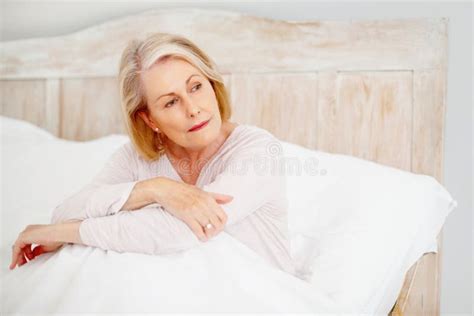 Relaxed Mature Woman In Bed Looking Away Portrait Of A Relaxed Mature Woman In Bed Looking Away