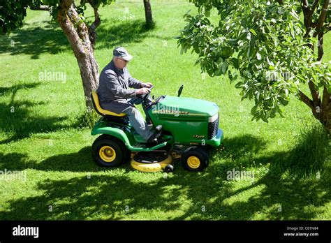 Elderly Man Mowing The Lawn On A John Deere Sit On Lawnmower Bengel