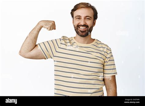 Smiling Happy And Healthy Man Showing His Muscles Flexing Biceps On