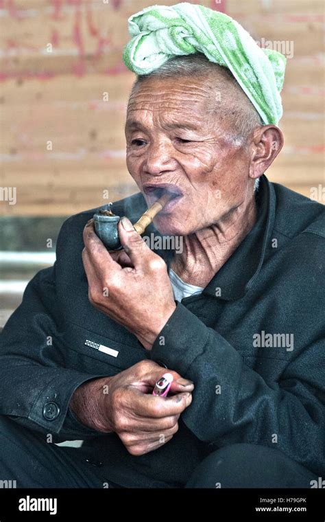 An Old Man Smokes A Pipe In The Tangan Village Over Zhaoxing In
