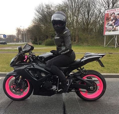 A Person Sitting On A Motorcycle In The Middle Of The Road With Pink Rims