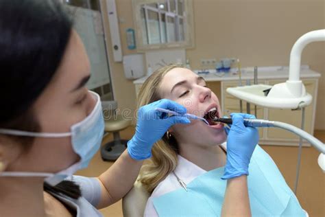 Dentist Woman Treats The Teeth Of A Young Patient With The Help Of