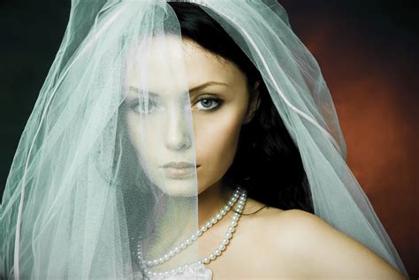 misterious brunette bride wearing a veil outdoor phone store