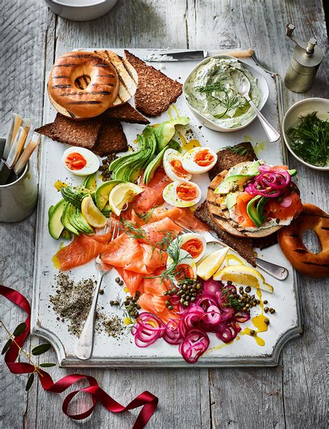 Classic additions for smoked salmon platters include bagels, cream cheese, cucumbers, dill, lemon, and a briny element such as capers or olives. Smoked salmon breakfast platter recipe | Sainsbury's Magazine