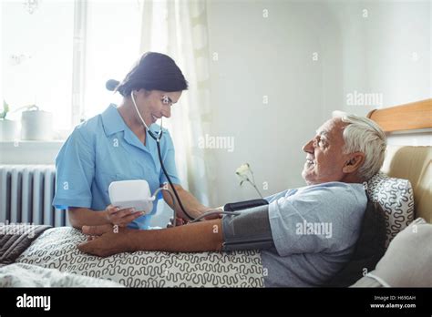 Nurse Checking Blood Pressure Of Senior Man Stock Photo Alamy