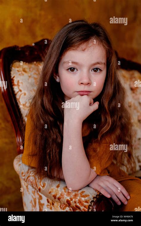Portrait Of Little Girl Sitting On Lounge Chair Stock Photo Alamy