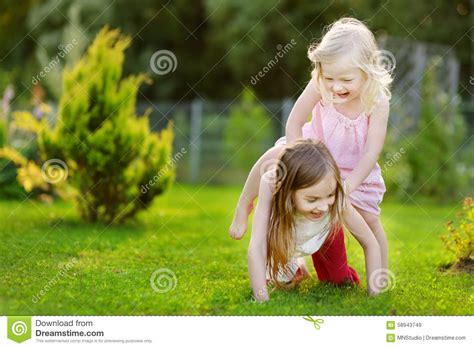 Two Cute Little Sisters Having Fun On The Grass Stock Image Image Of Active Daughter 58943749