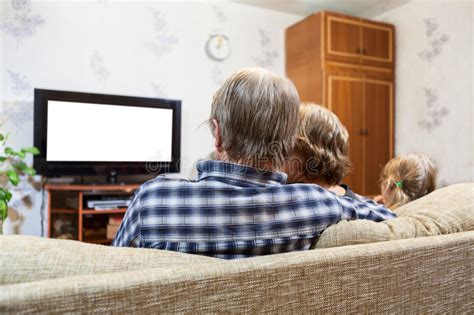 Padres Caucásicos E Hija Que Se Sientan En El Sofá Y Tv De Observación