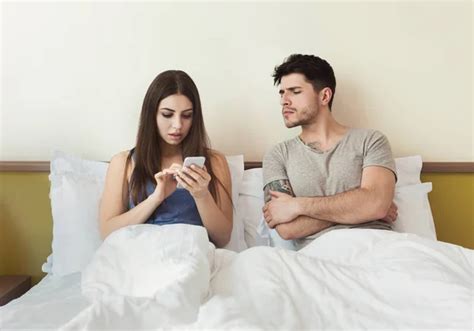 Jealous Husband Watching Wife Mobile Phone On The Bed Stock Image