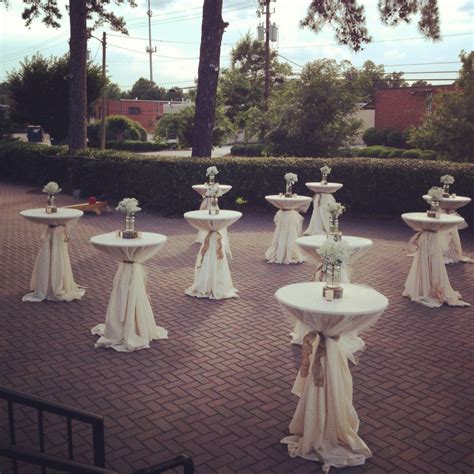Outdoor cocktail tables with tulle overlays, burlap ties and baby's