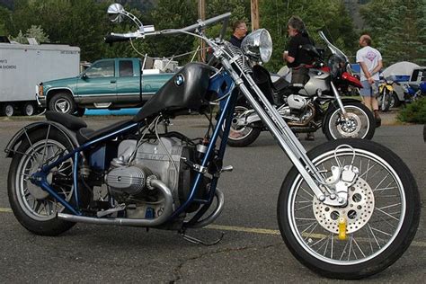 Two Motorcycles Parked Next To Each Other In A Parking Lot With People