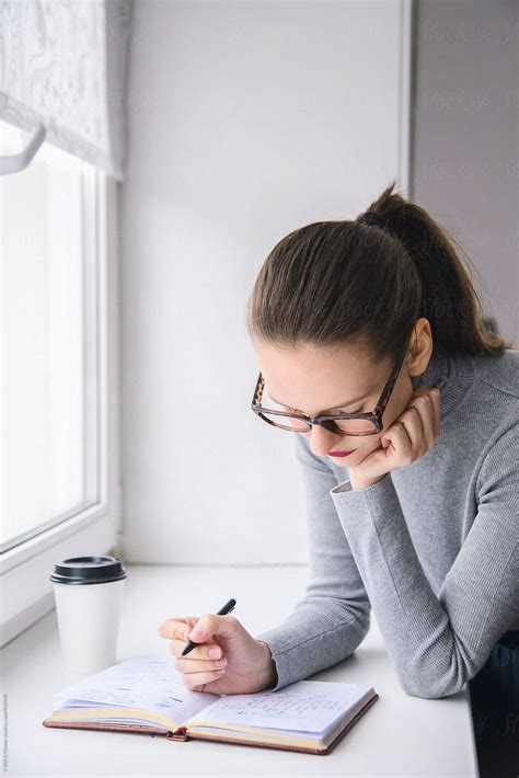 Babe Woman Looking Down In Daily Planner By Stocksy Contributor