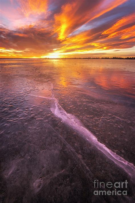 Colorful Sunrise On The Frozen Lake With Ice Cracks Glowing Photograph
