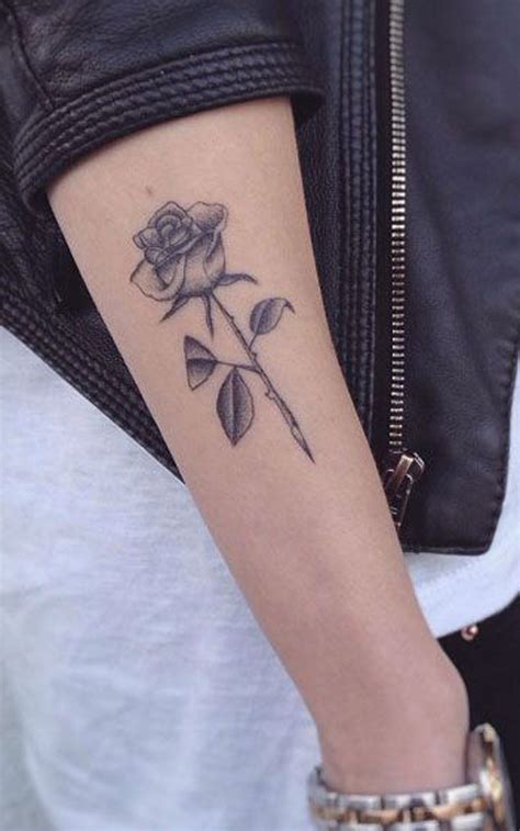 A Womans Arm With A Rose Tattoo On The Left Side Of Her Arm