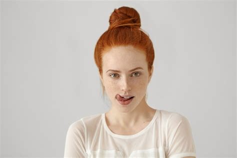 Free Photo Headshot Of Attractive Tempting Woman Wearing Ginger Hair In Knot Licking Her Lips