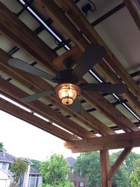 It will keep things cool during the summer and the motor can be reversed to warm the space during the colder months. Outdoor ceiling fan installed under solar pergola ...