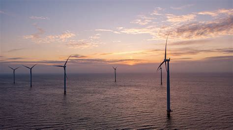 Windmill Park Green Energy During Sunset In The Ocean Offshore Wind