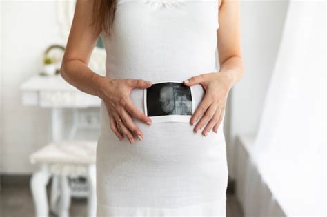 妊娠中の女性が下着姿で彼女の腹に触れる 無料の写真