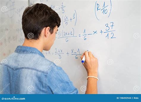 College Student Solving Math Equation On White Board Stock Photo