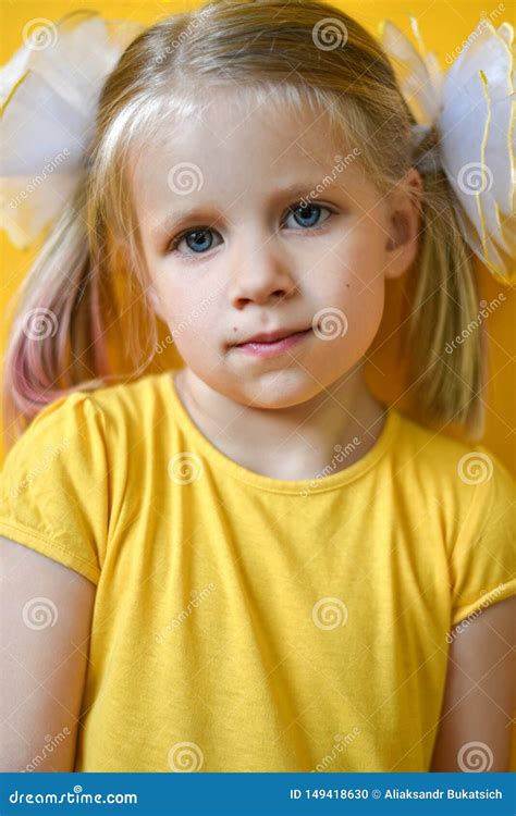 Portrait Of Little Girl In A Yellow Dress On A Yellow Background Stock