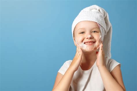 Premium Photo A Little Girl With A Towel On Her Head Washes Her Face