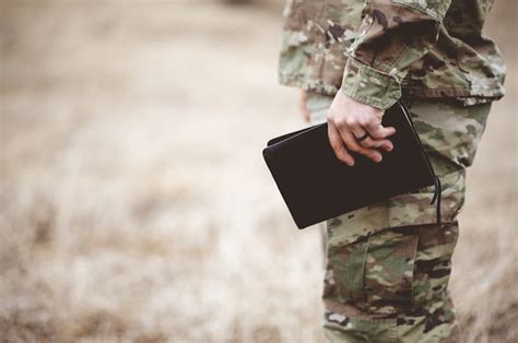 Free Photo Shallow Focus Shot Of A Young Soldier Holding A Bible In A