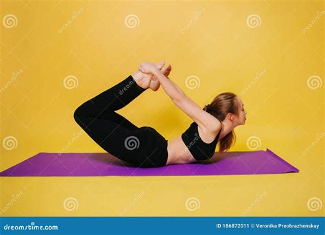 Athletic Beautiful Young Girl Practicing Yoga Makes The Pose Of Dhanurasana Wear Black