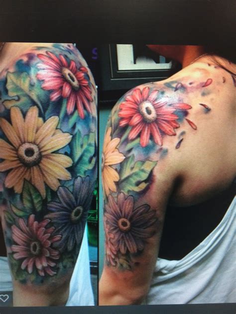 A Womans Arm With Flowers On It And The Back Of Her Arm Is Covered In