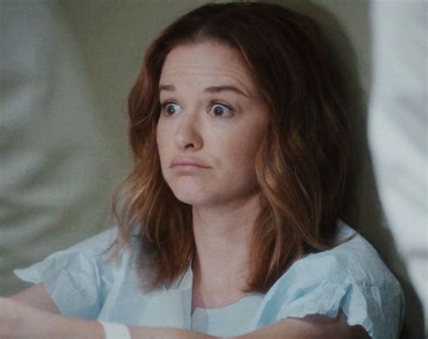 A Woman Sitting On A Bed Looking At The Camera