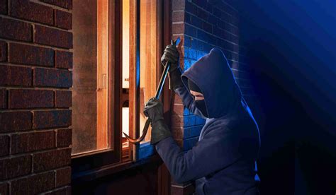 Burglar Using Crowbar To Break Into A House At Night With Room Left And