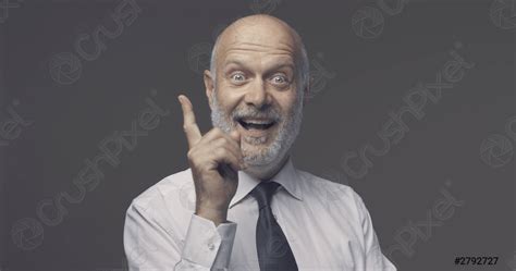 Cheerful Businessman Pointing Upwards And Smiling Stock Photo 2792727