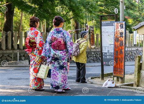 Two Female Tourists In Traditional Colorful Japanese Kimono Taking Photo With A Selfie Stick In