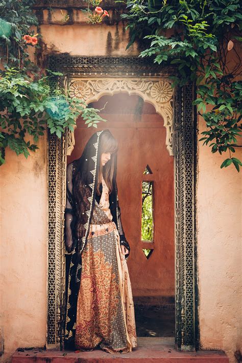 A Young Women Standing In An Ornate Doorway Wearing A Patterned Maxi