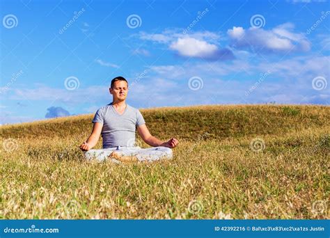 The Peaceful Scenery Of A Man Meditating In The Lotus Position Stock