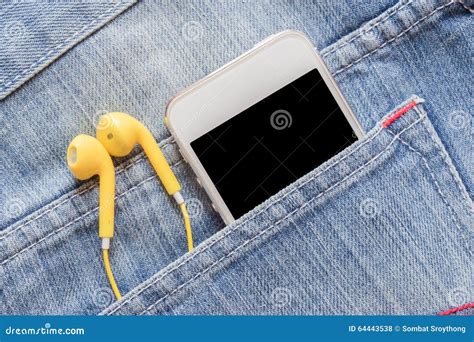 Closeup Smartphone And Yellow Earphone In Denim Jeans Pocket Stock