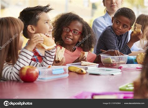 Young School Kids Eating Lunch Talking Table Together — Stock Photo