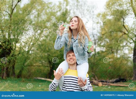 Jong Mooi Meisje Op De Rug Van Een Jonge Mens In Openlucht In De Zomer 1 Stock Afbeelding