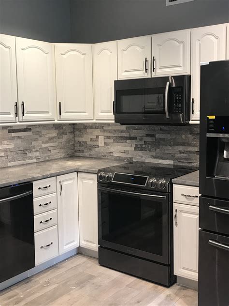 Black cabinets are an elegant option that feels way more glam than plain white. Stackstone backsplash, black stainless appliances White ...