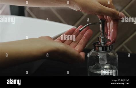 Girl Presses On Bottle Of Liquid Soap And Pours A Portion Of Soap Into