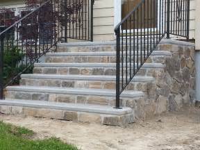 A Set Of Stone Steps Leading Up To A House With Wrought Iron Railing
