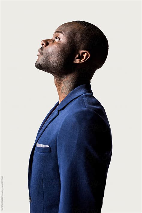 Profile Portrait Of Young Black Man Looking Up Against A White B By