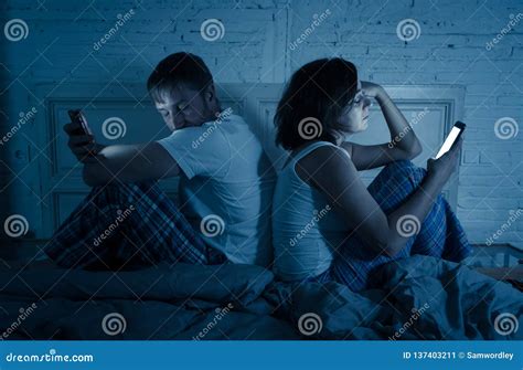 Couple In Bed On Mobile Phones Ignoring Each Other In Relationship Problems And Technology
