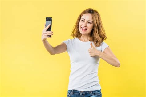 Free Photo Smiling Young Woman Showing Thumb Up Sign Taking Selfie On