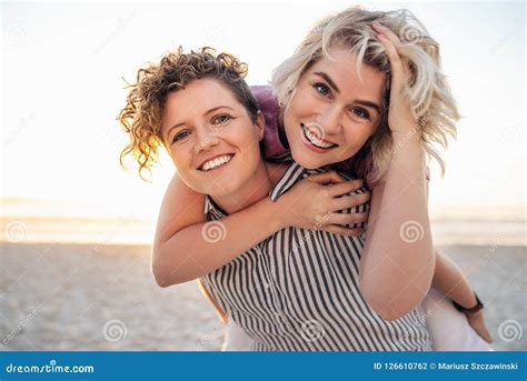 Laughing Young Lesbian Couple Having Fun Together At The Beach Stock