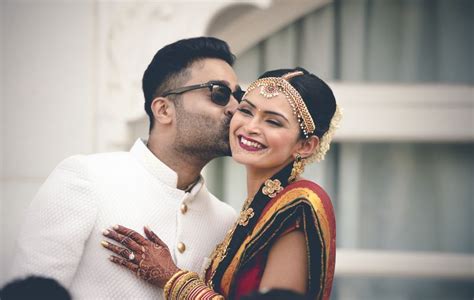 photo of south indian wedding with groom kissing bride