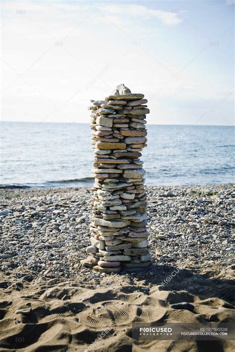 Pile Of Stones On Beach With Sea Water On Background — Vertical
